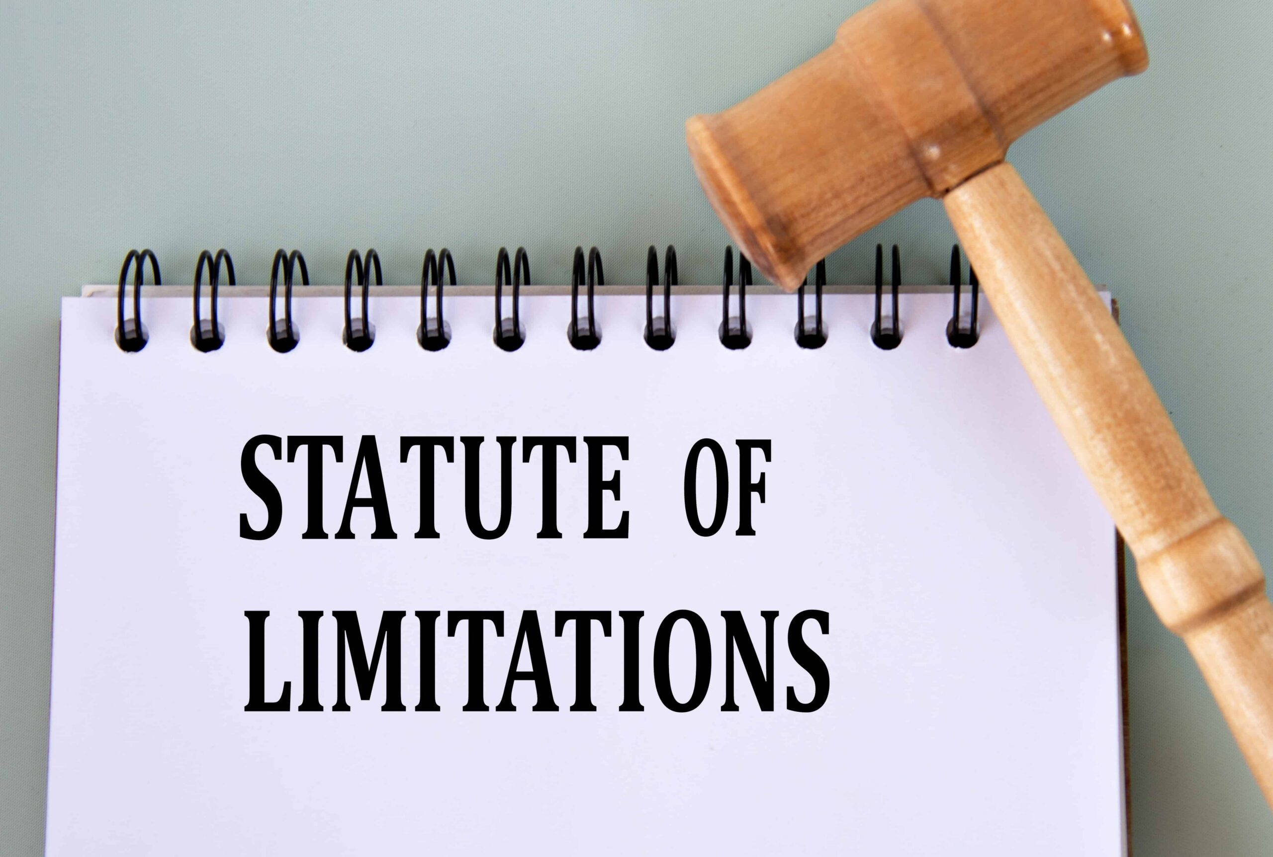 Statute of limitations text on notepad with wooden gavel, representing legal deadline for filing a lawsuit.