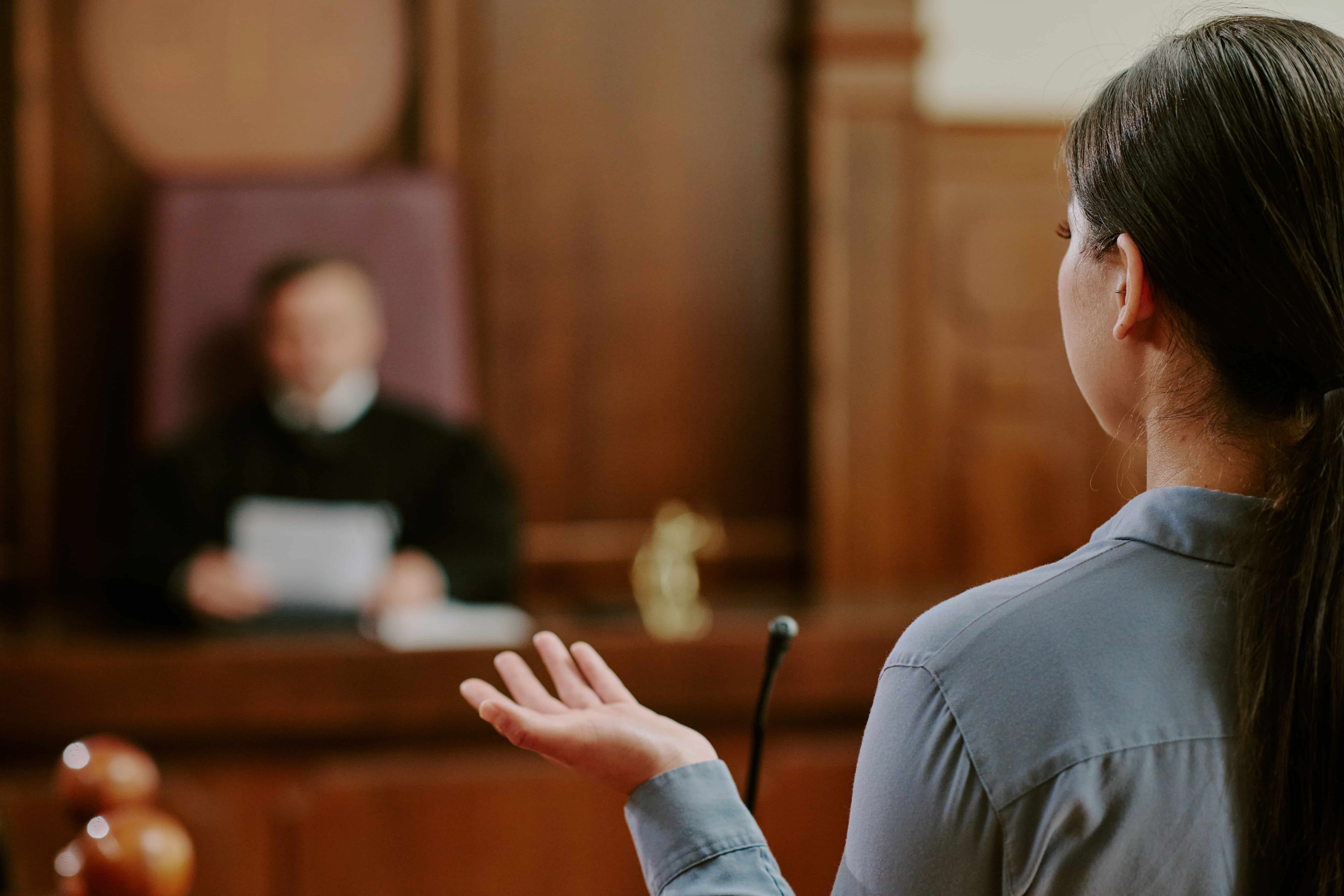 Witness testifying in court while addressing the judge during a legal proceeding.